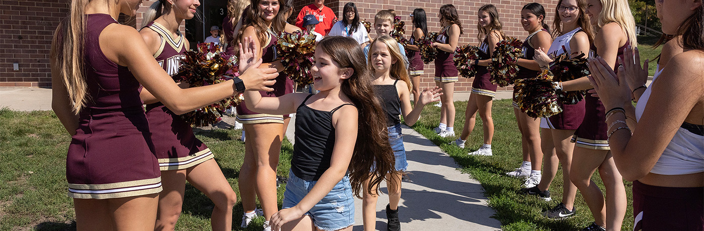 students high-fiving Lincoln cheerleaders